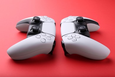 Two wireless game controllers on red background