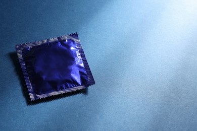 Photo of Condom package on blue background, space for text. Safe sex