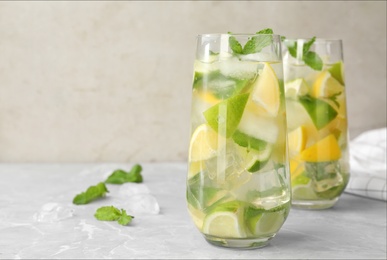 Glasses of refreshing lemonade on marble table, space for text. Summer drink