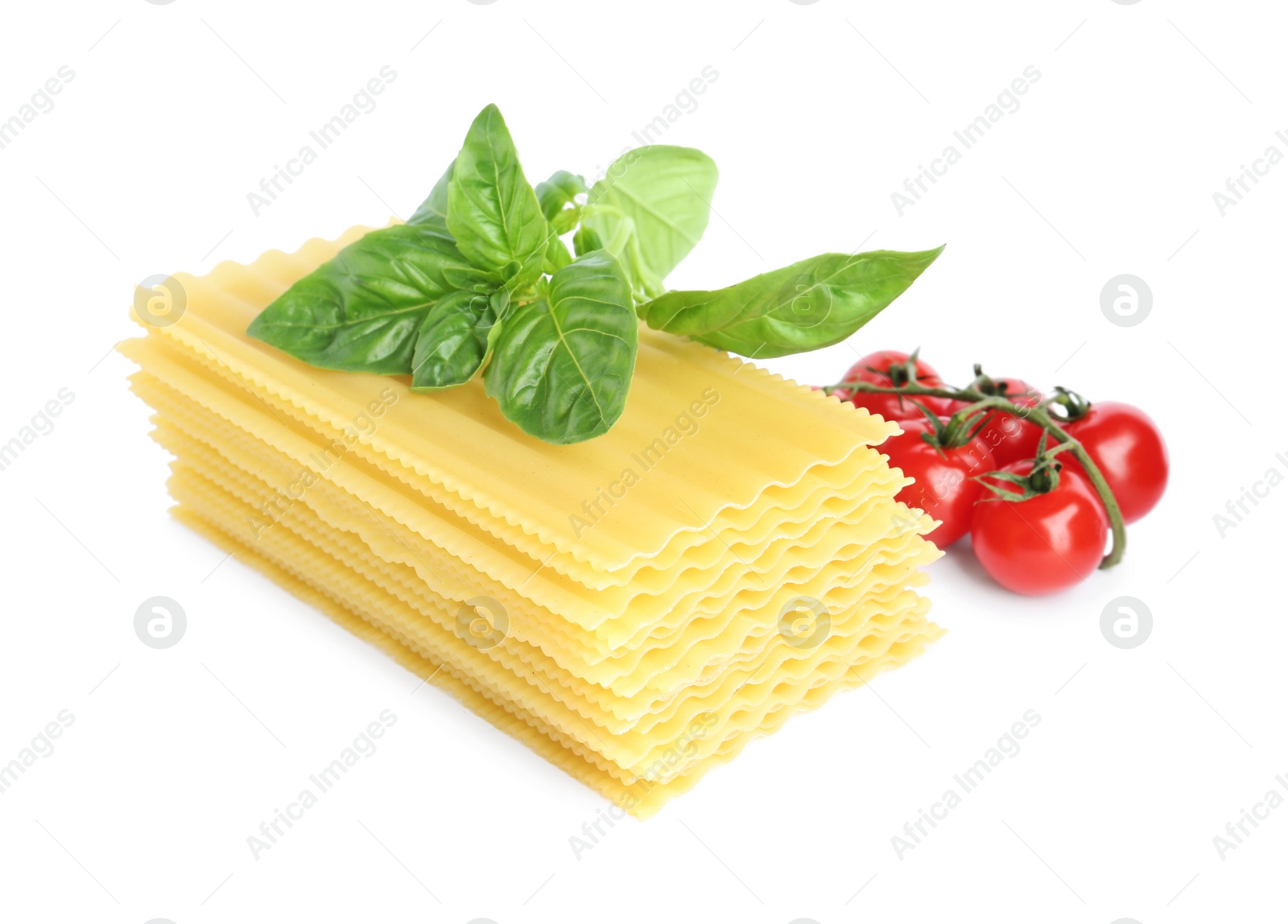 Photo of Uncooked lasagna sheets, cherry tomatoes and basil isolated on white