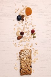 Tasty granola bar and ingredients on white wooden table, top view