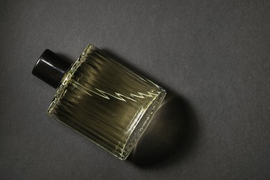 Photo of Luxury men`s perfume in bottle on black background, top view. Space for text