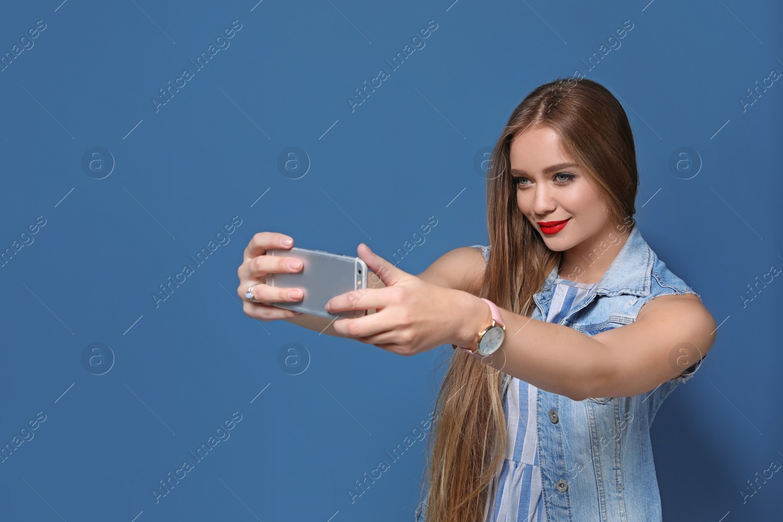 Photo of Attractive young woman taking selfie on color background