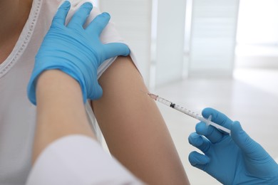 Photo of Doctor giving injection to woman in hospital, closeup. Immunization concept