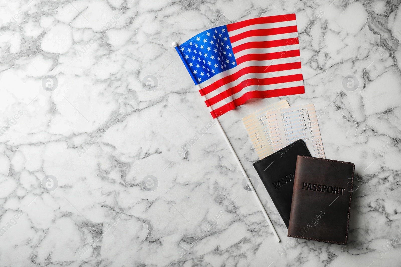 Photo of Flat lay composition with flag of USA and passports on marble background. Space for text