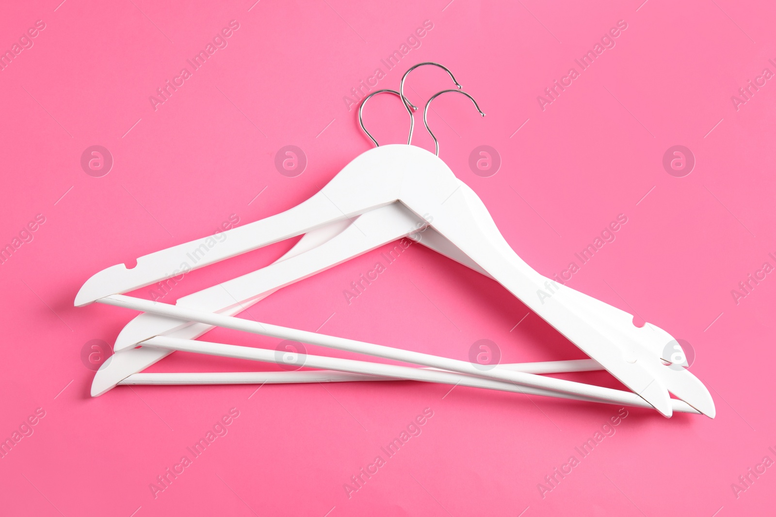 Photo of Empty clothes hangers on color background, top view