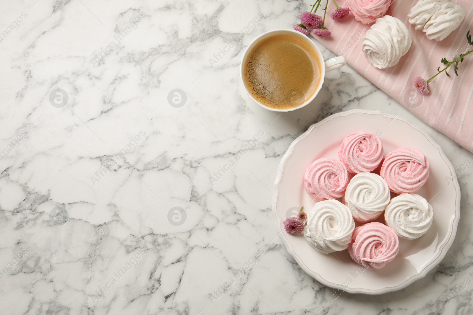 Photo of Delicious marshmallows and cup of coffee on white marble table, flat lay. Space for text
