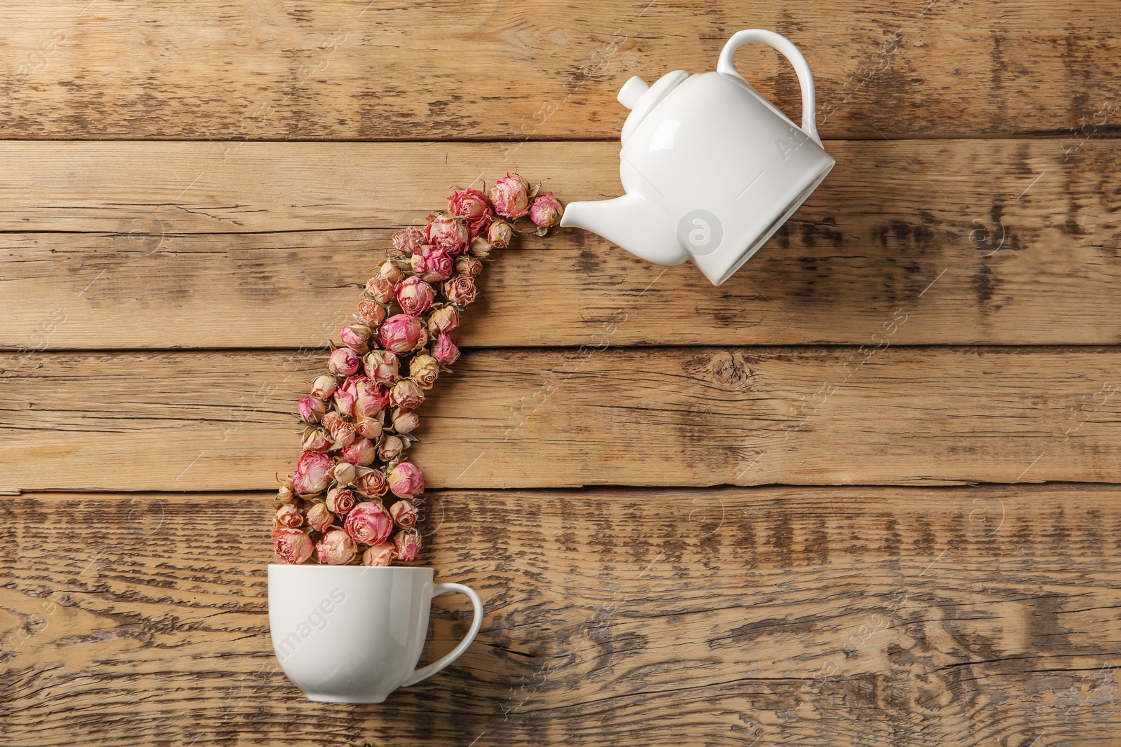 Photo of Flat lay composition with teapot, cup and dried roses on wooden background