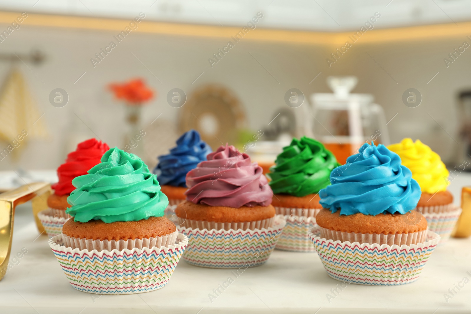 Photo of Delicious cupcakes with colorful cream on white board