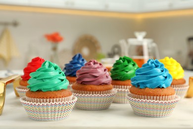 Delicious cupcakes with colorful cream on white board