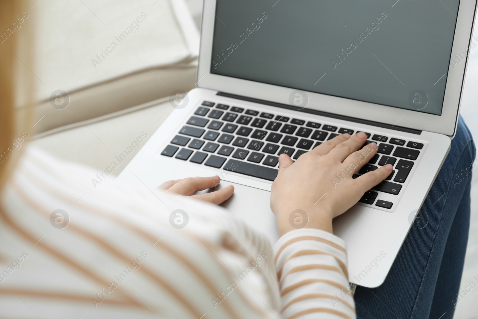 Photo of Woman working on modern laptop at home, closeup