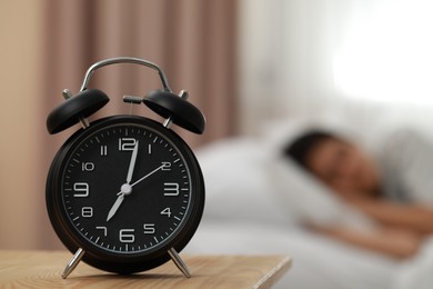 Photo of Woman sleeping in bedroom, focus on alarm clock. Space for text