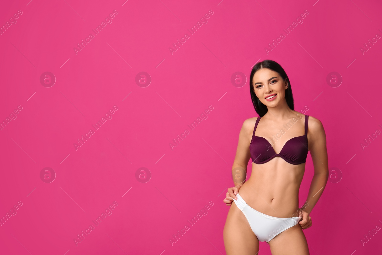 Photo of Beautiful young woman in stylish bikini on pink background. Space for text