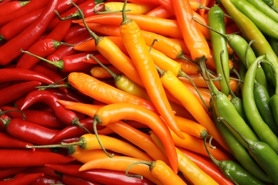 Photo of Different ripe chili peppers as background, top view
