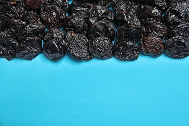 Photo of Tasty prunes on color background, top view with space for text. Dried fruit as healthy snack