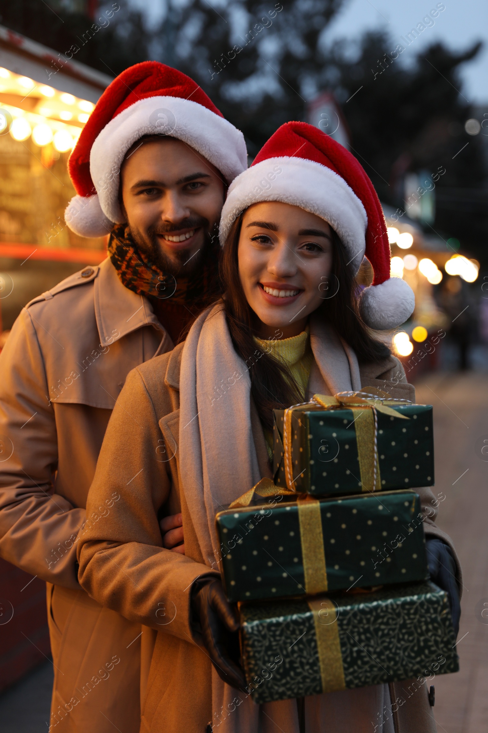 Photo of Lovely couple with Christmas presents at winter fair