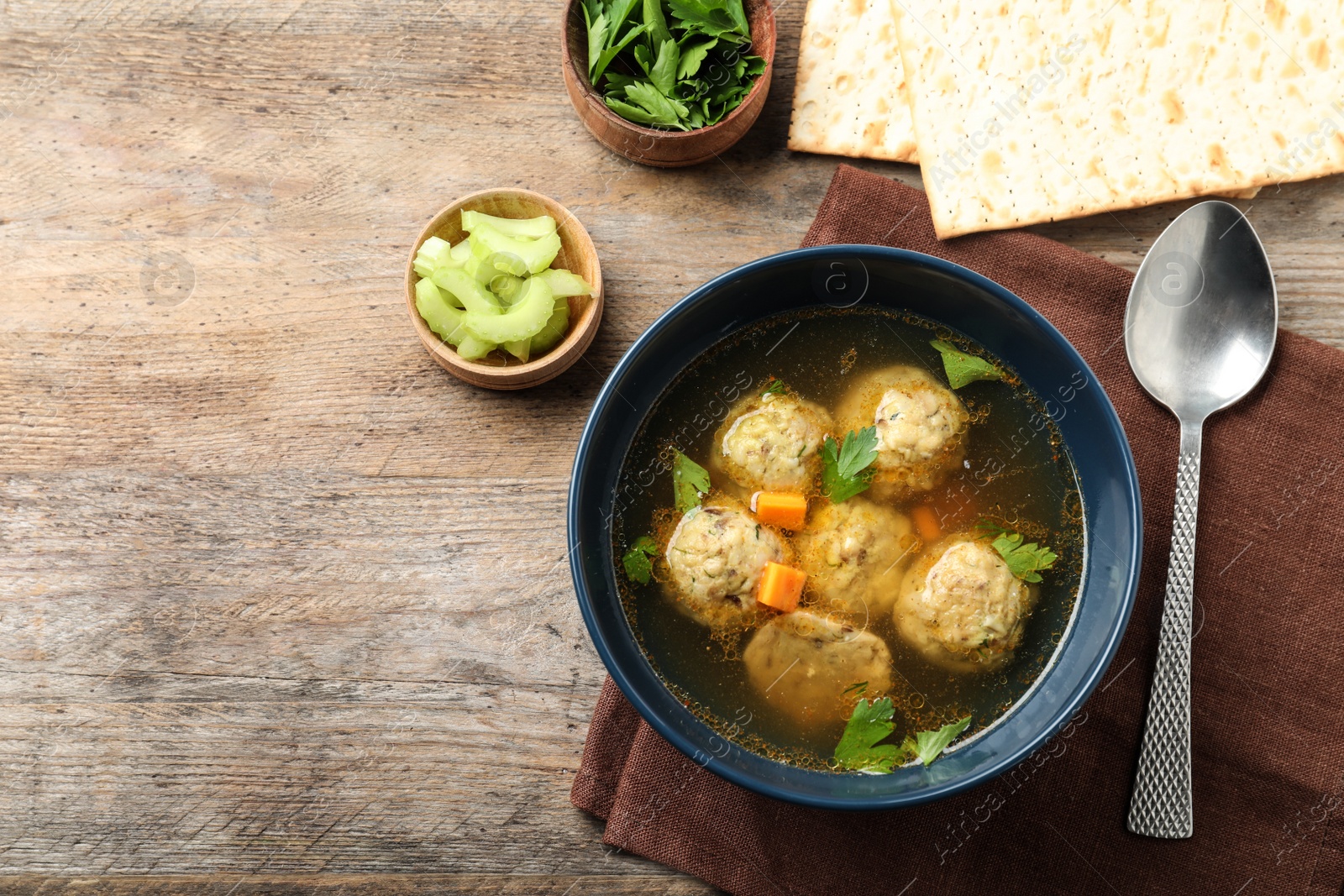 Photo of Flat lay composition with Jewish matzoh balls soup on wooden table. Space for text