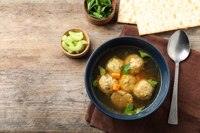 Photo of Flat lay composition with Jewish matzoh balls soup on wooden table. Space for text