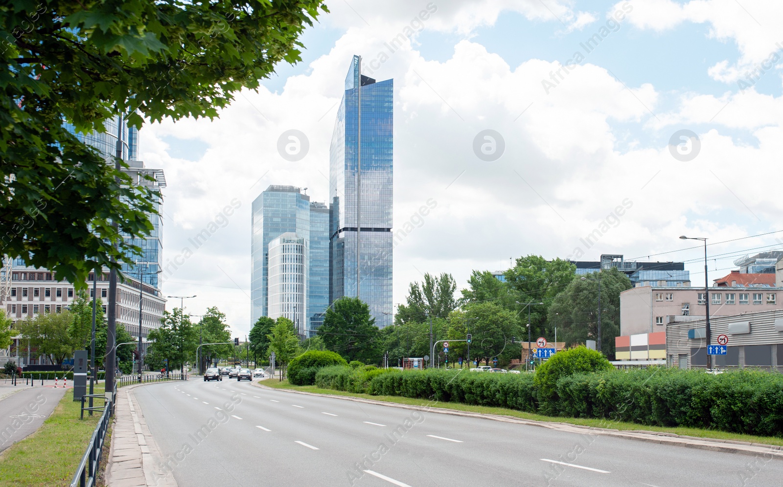 Photo of Road, cars and beautiful buildings on cloudy day in city