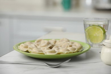 Photo of Delicious dumplings on table in kitchen, closeup