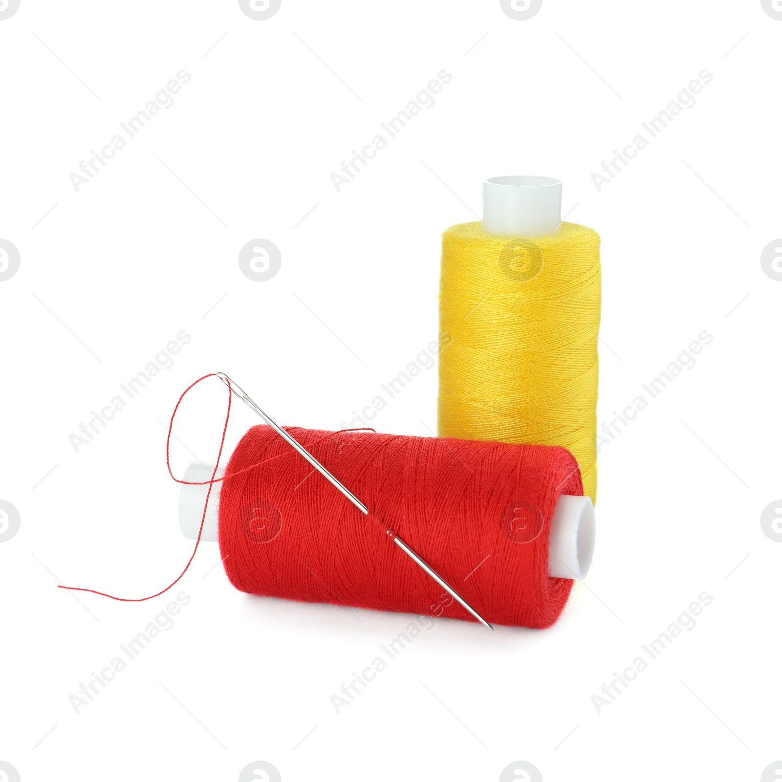 Photo of Different colorful sewing threads and needle on white background