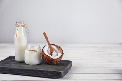 Photo of Composition with fresh coconut oil on white wooden table, space for text. Cooking ingredient