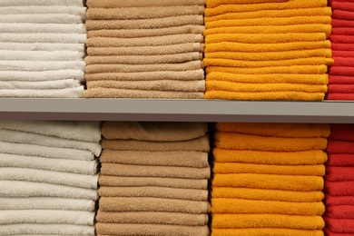 Stacks of colourful towels on store shelves