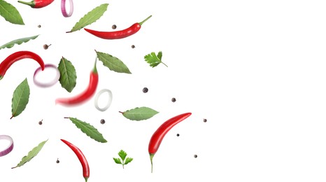 Image of Bay leaves, parsley, onion rings, black and fresh red hot peppers flying on white background