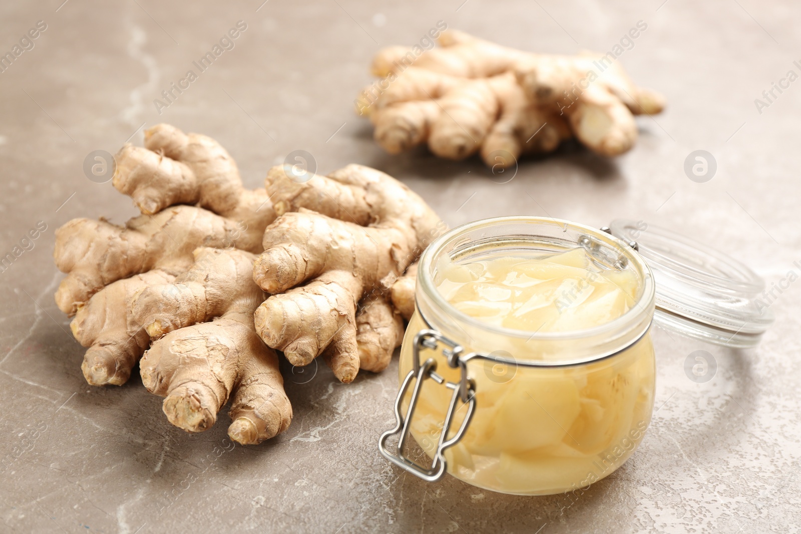 Photo of Spicy pickled ginger and root on grey table