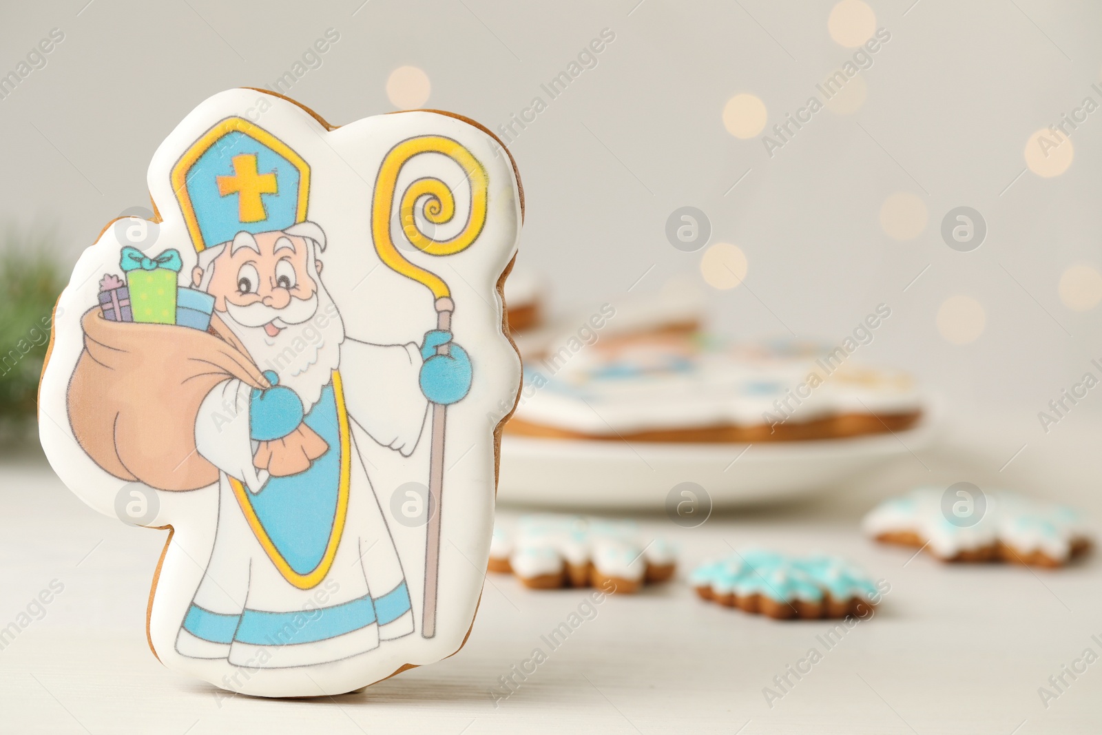 Photo of Delicious gingerbread cookies on white wooden table, closeup with space for text. St. Nicholas Day celebration