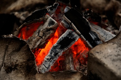 Photo of Beautiful bonfire with smoldering firewood, closeup view