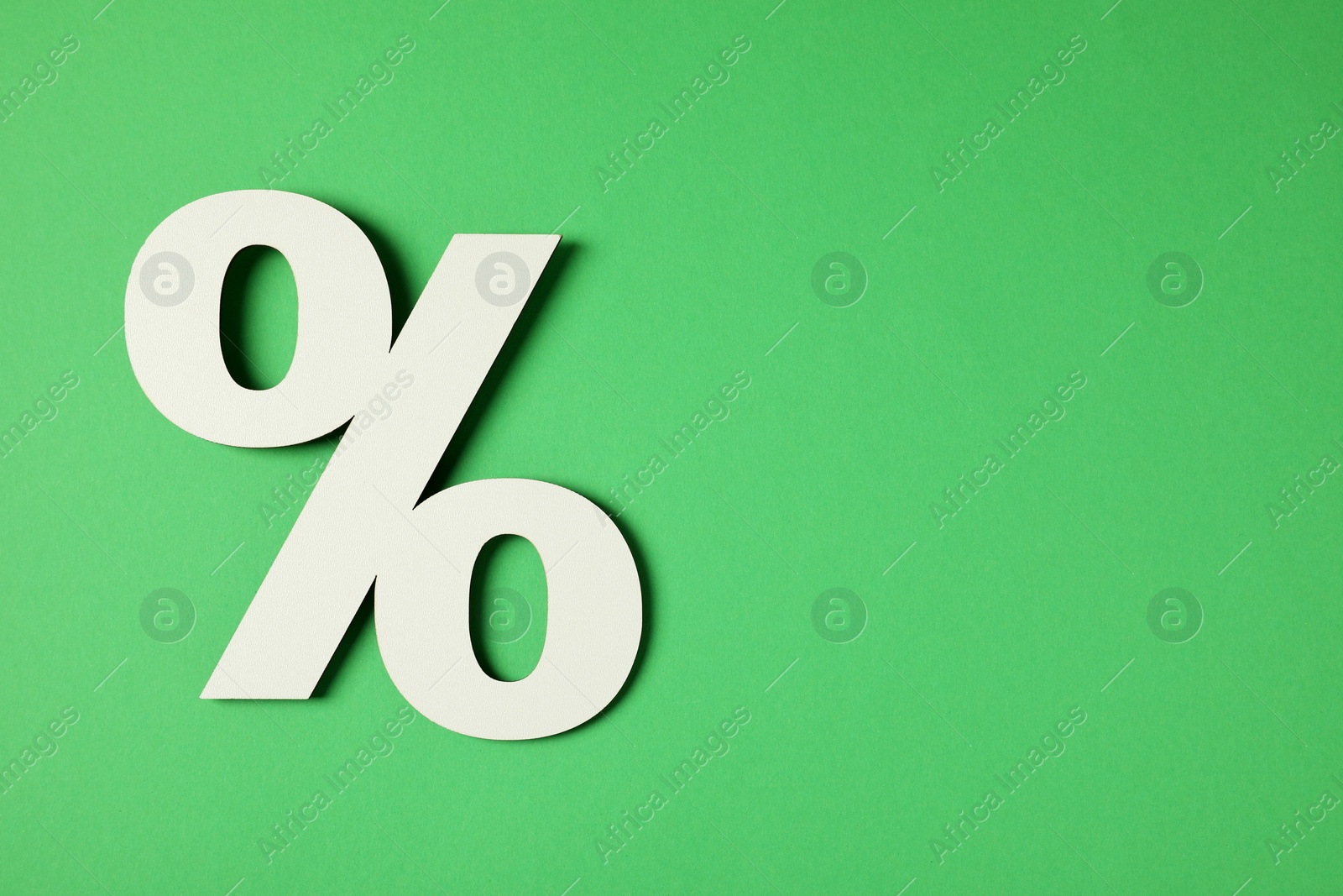 Photo of Wooden percent sign on green background, top view