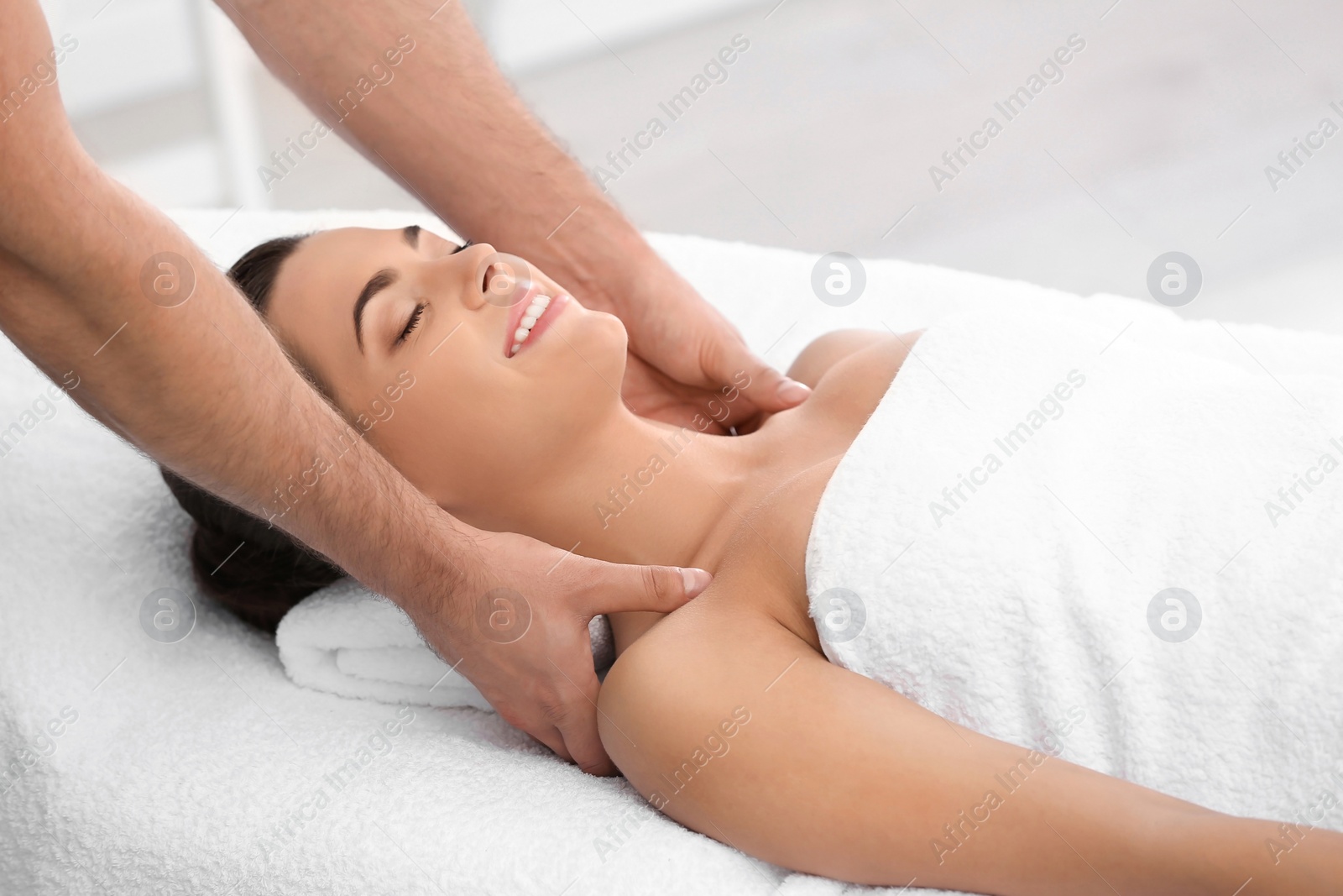 Photo of Relaxed woman receiving shoulders massage in wellness center