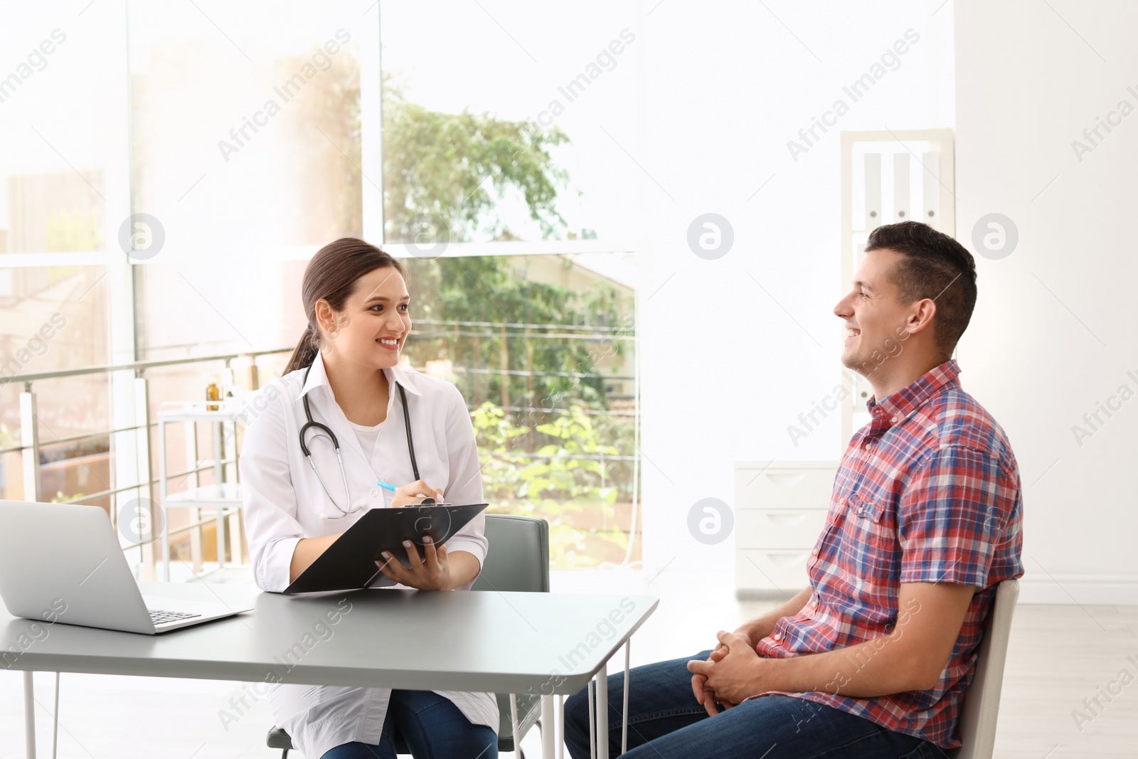 Photo of Young doctor speaking to patient in hospital