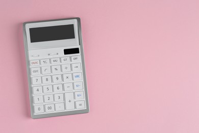 Photo of White calculator on pink background, top view. Space for text