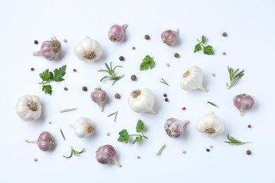 Fresh raw garlic heads and spices on white table, flat lay