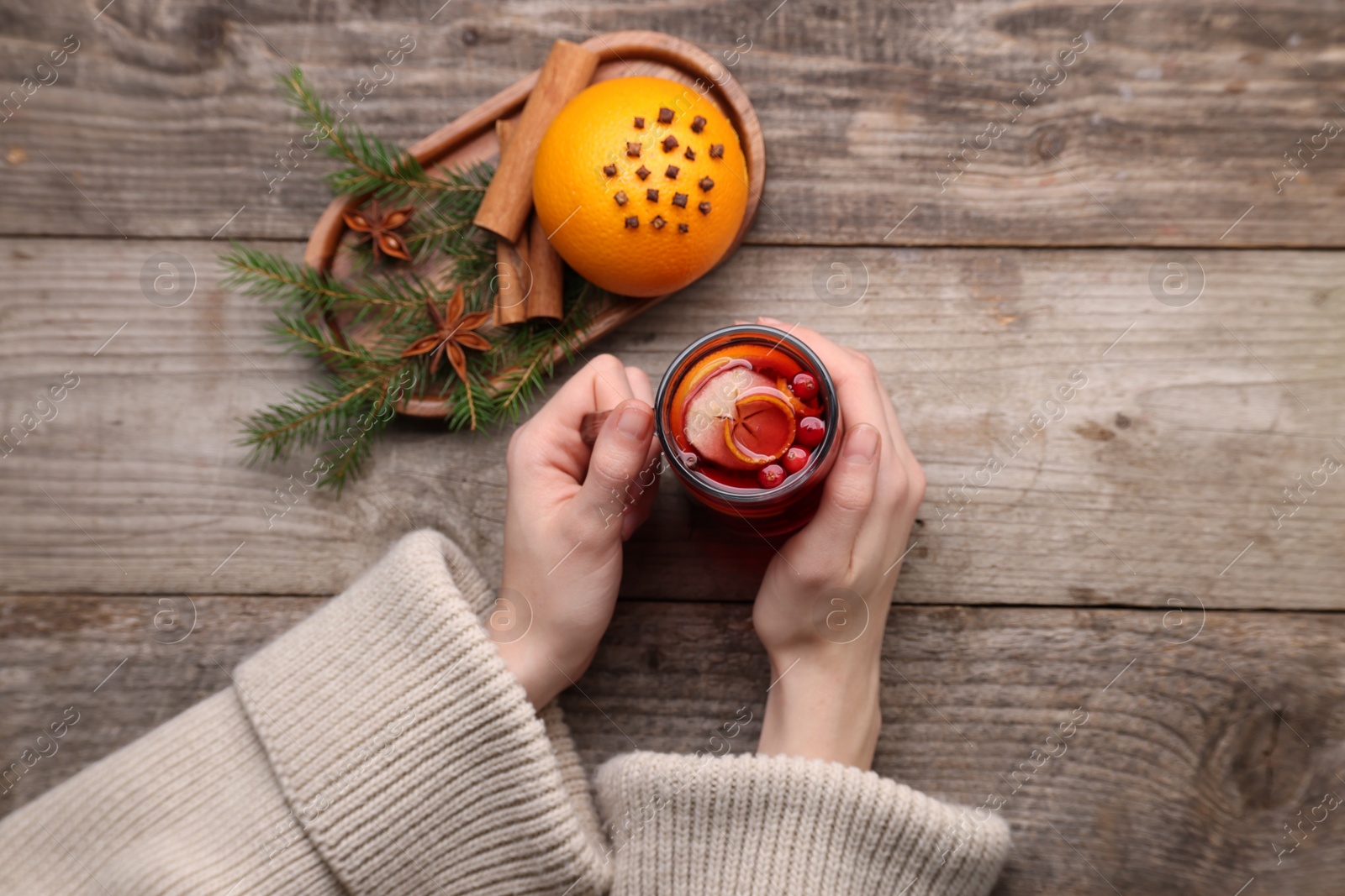 Photo of Woman with cup of aromatic mulled wine, top view