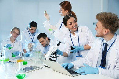 Group of scientists working in modern chemistry laboratory