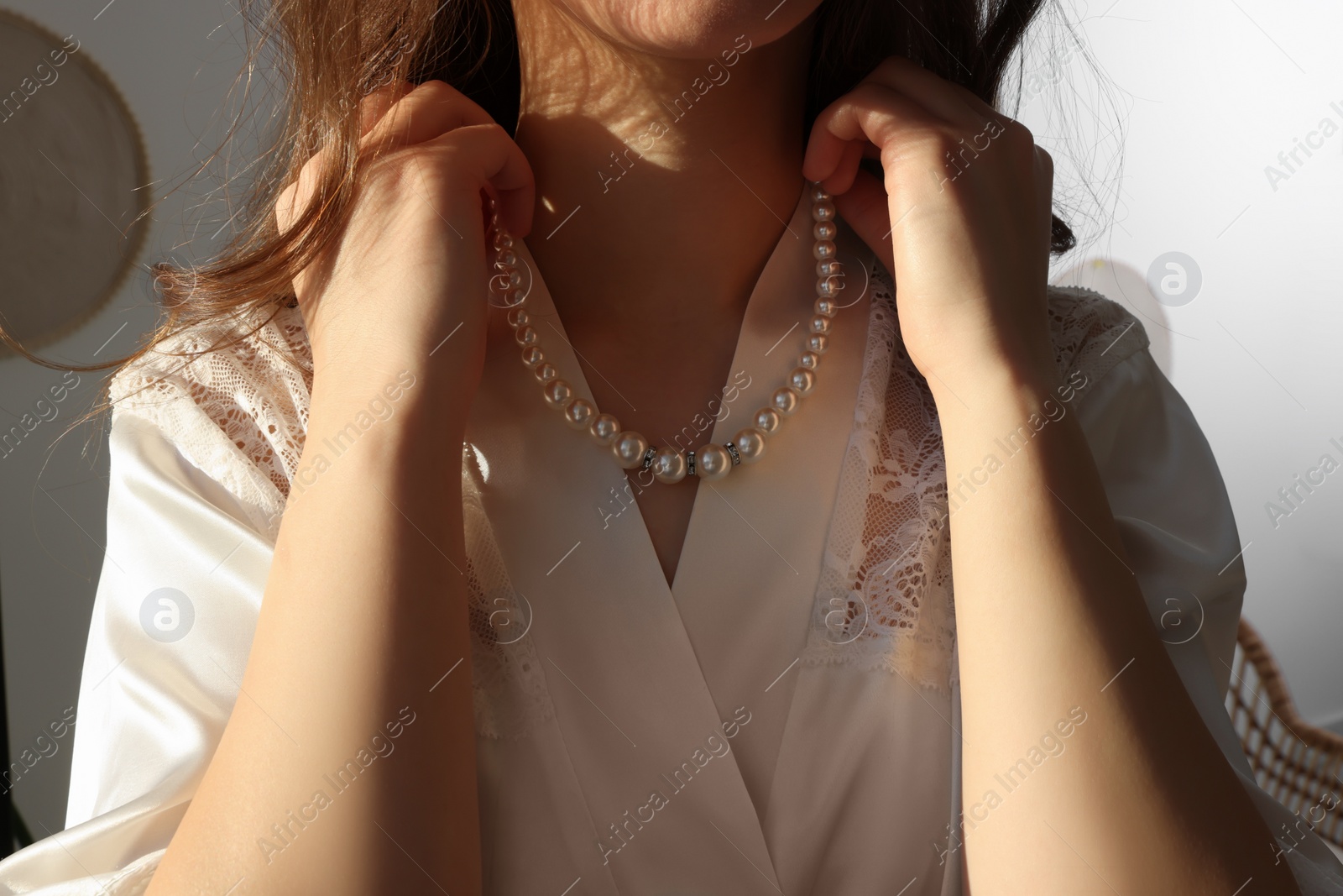 Photo of Bride with beautiful pearl necklace indoors, closeup. Wedding day