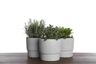 Photo of Pots with sage, mint and rosemary on wooden table against white background