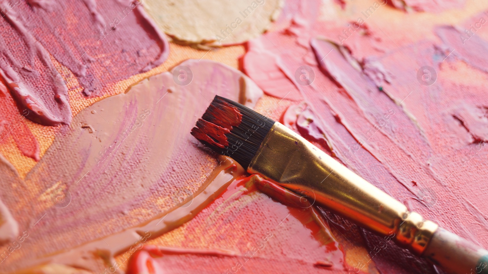 Photo of Brush on artist's palette with mixed paints, closeup