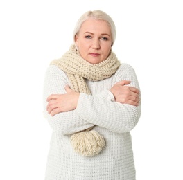 Mature woman in warm clothes suffering from cold on white background