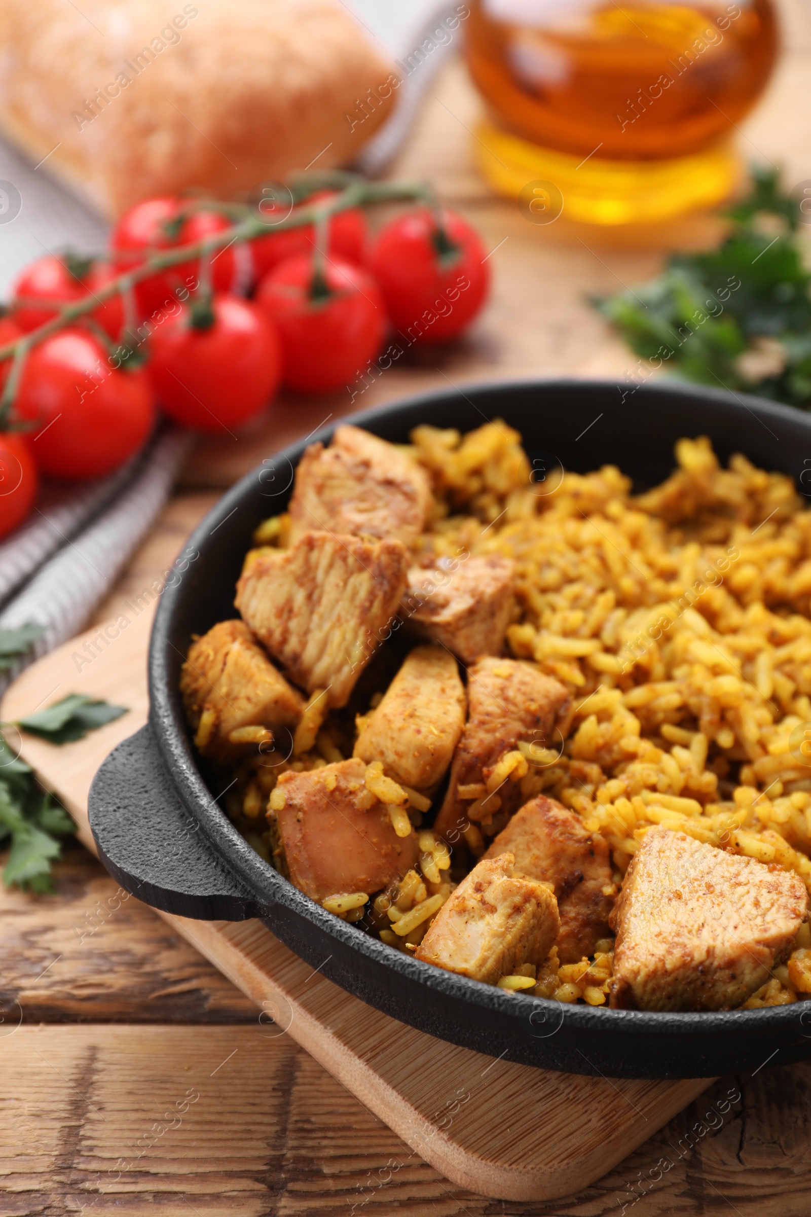 Photo of Delicious rice with chicken served on wooden table