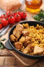 Delicious rice with chicken served on wooden table