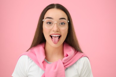 Photo of Happy woman showing her tongue on pink background