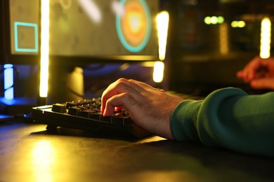 Man playing video games on computer at table, closeup