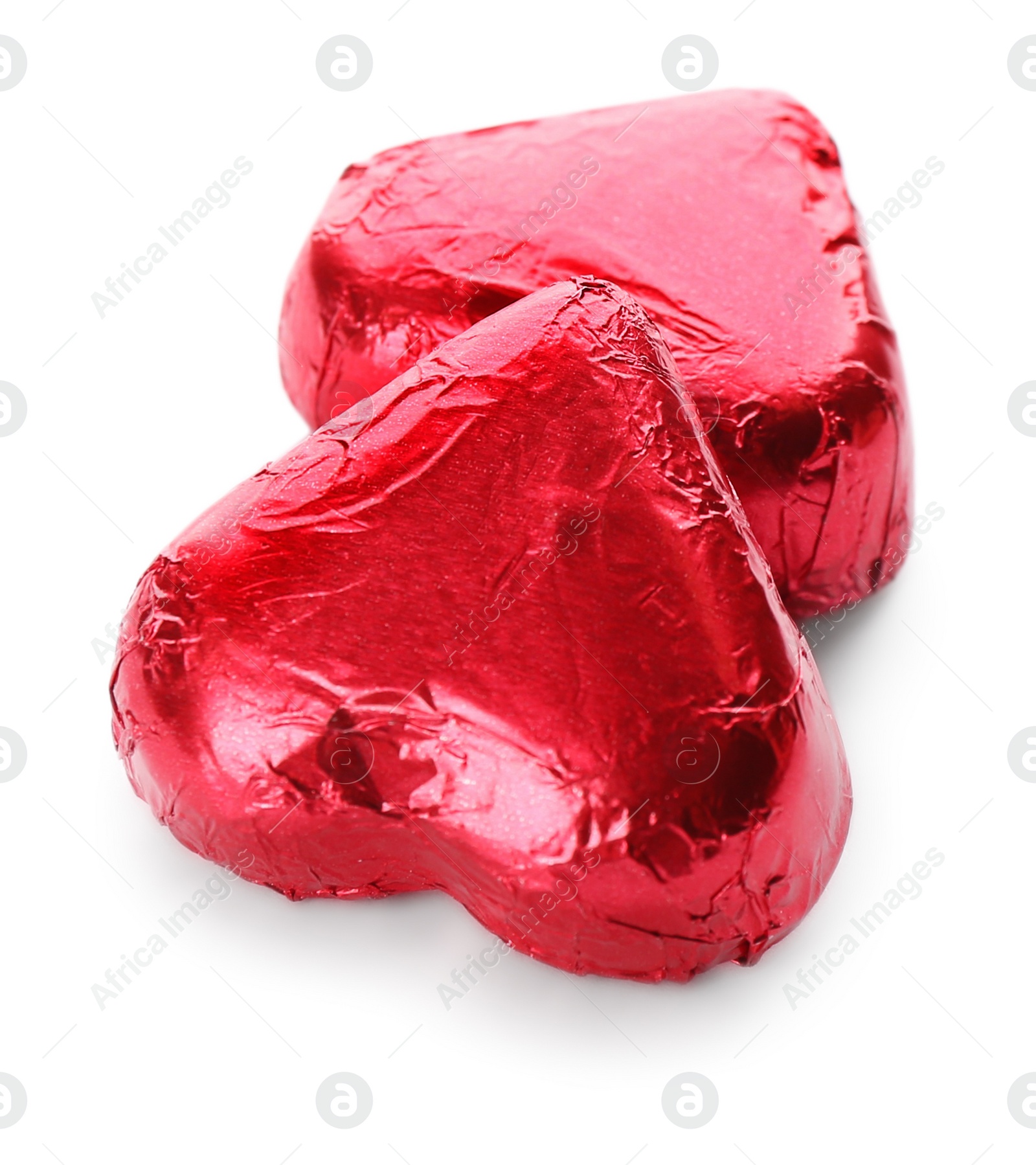 Photo of Heart shaped chocolate candies in red foil on white background