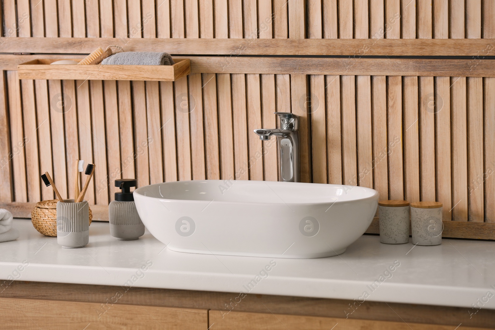 Photo of Stylish vessel sink near wooden wall in modern bathroom