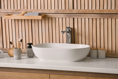 Photo of Stylish vessel sink near wooden wall in modern bathroom