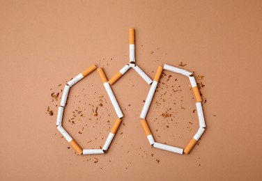No smoking concept. Lungs made of cigarettes and dry tobacco on brown background, flat lay